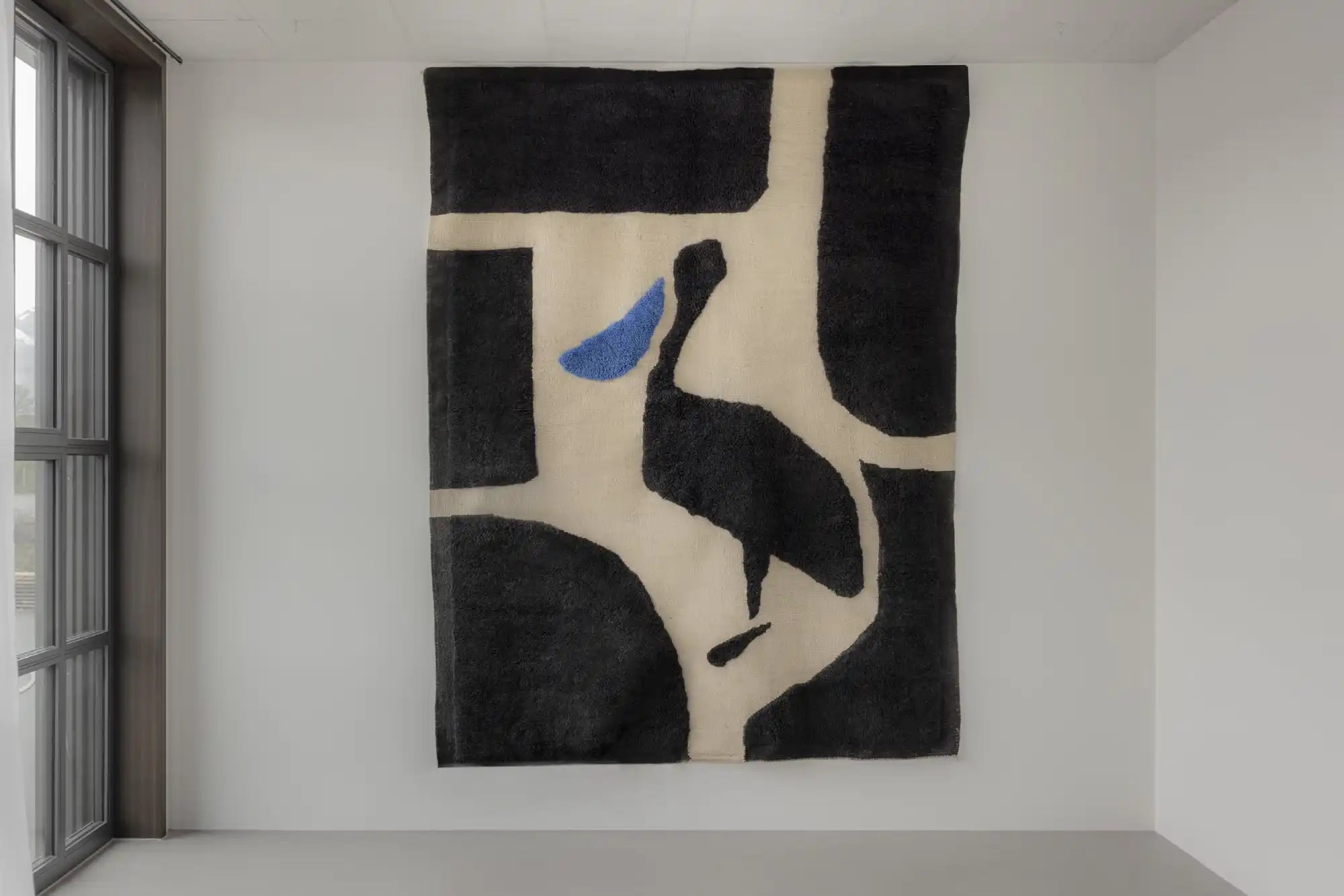 Minimalist artwork featuring a black pelican silhouette with a blue accent against a cream background.