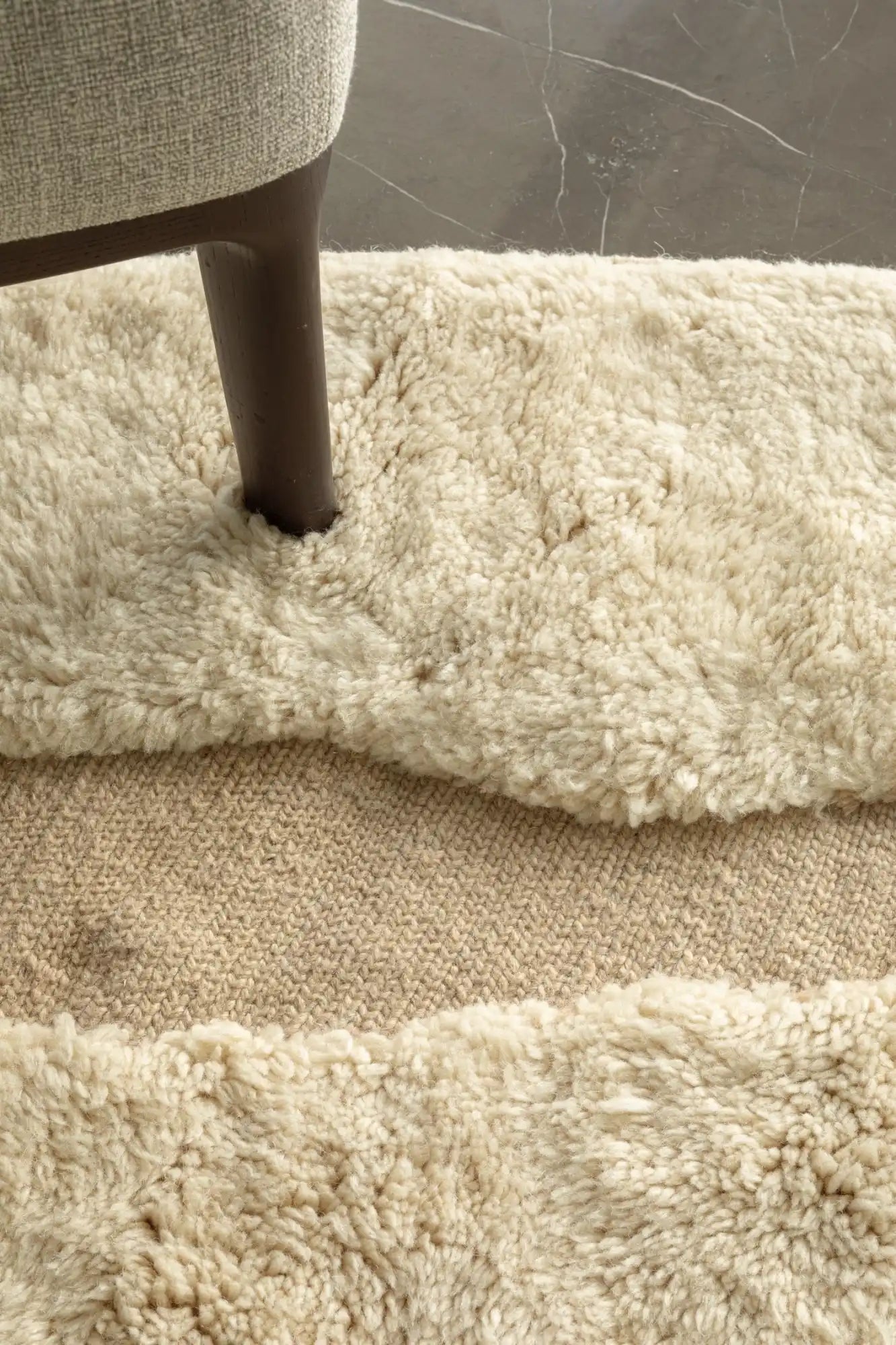 Plush cream-colored shag rug with visible furniture leg.